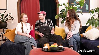 Blonde with braid and brunette talk on blue couch