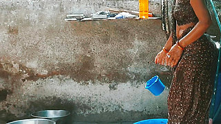 In the country's bathroom of the village, the elder sister-in-law's stepsister is soaking her saree in water and bathi