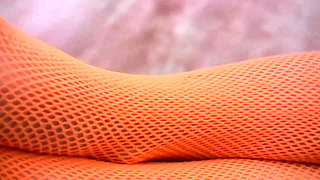 Babe in fishnet outfit rips pantyhose and puts a dildo in her shaved cunt